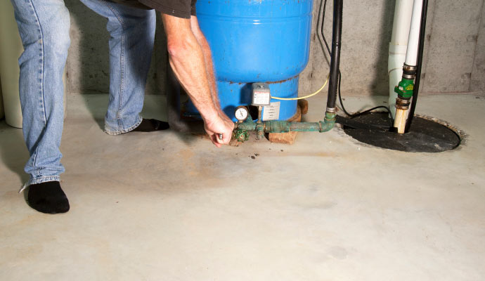 Professional worker installing sump pump