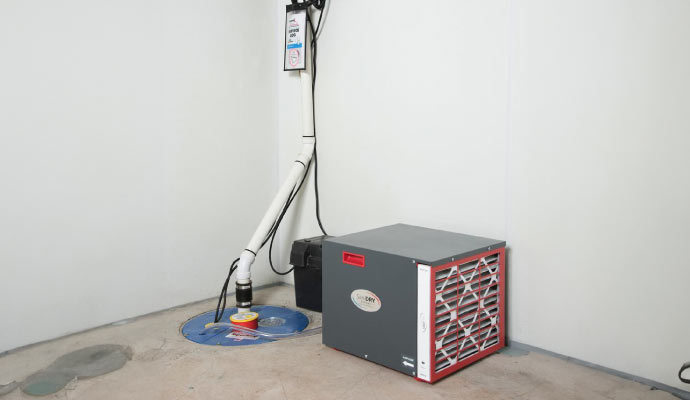 an installed sump pump alongside a dehumidifier in a basement